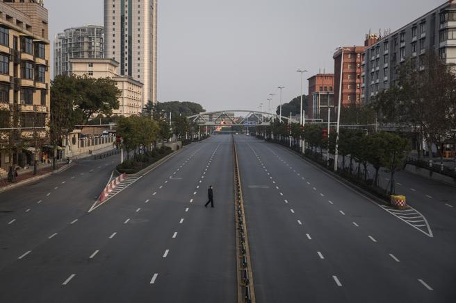 Un hombre cruza una calle desierta en Wuhan