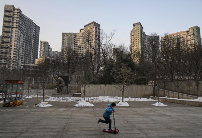 Un niño con una máscara patina en una zona residencial de Pekín
