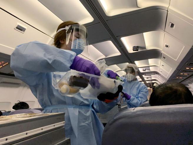 Azafatas con trajes protectores sirven comida a ciudadanos canadienses evacuados de China por el coronavirus