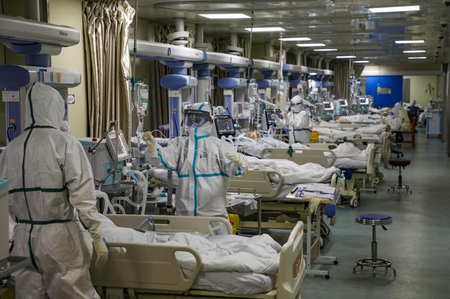 Personal sanitario con trajes protectores atienden a pacientes con coronavirus en la UCI de un hospital de Wuhan