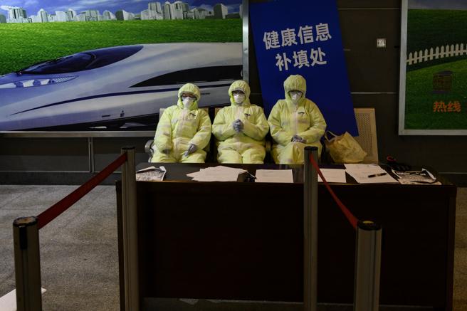 Personal sanitario con trajes protectores en una estación ferroviaria de Shangai