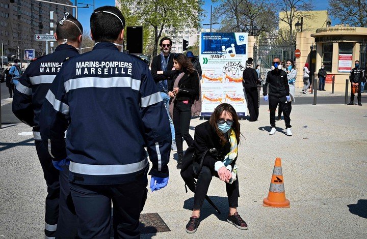 Decenas de personas esperaban este jueves ser revisadso en un instituto de Marsella, para determinar si tienen síntomas compatibles con el coronavirus.  (AFP)